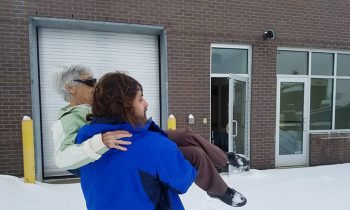 Doctor Opens Office And Carries Elderly Patient Through Snow-Filled Parking Lot